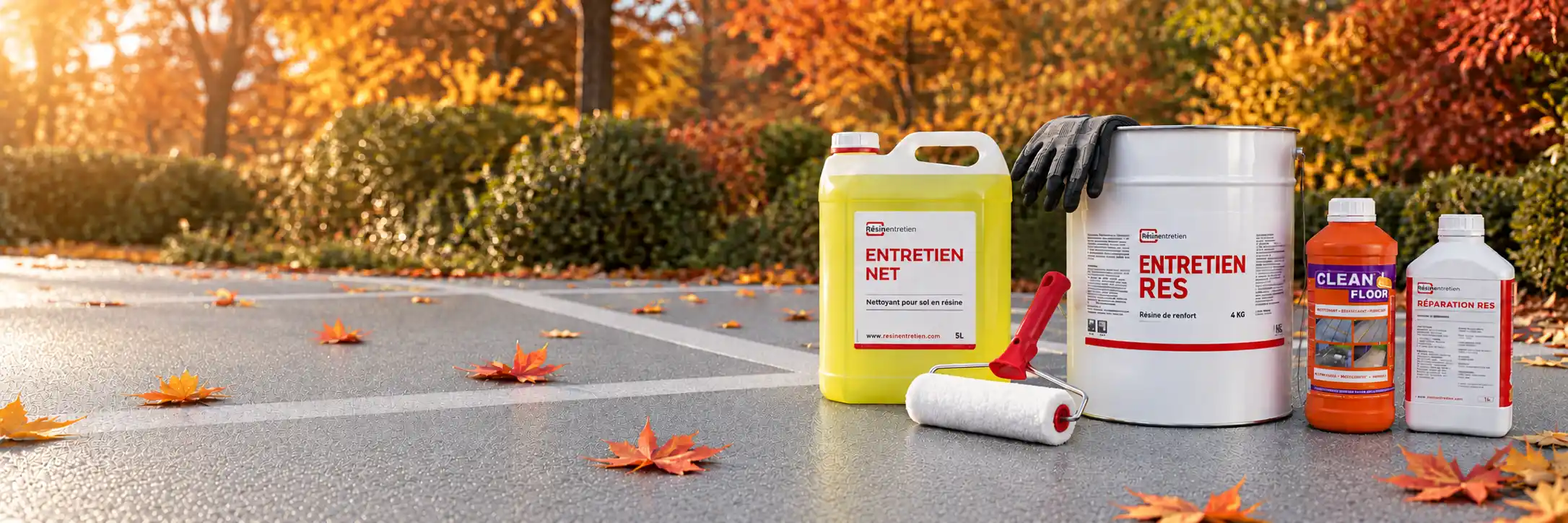 Produits d'entretien R&eacute;sine Entretien pos&eacute;s sur une moquette de pierre grise couverte de feuilles d'automne